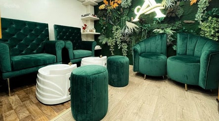 Elegant seating area at Luna Belleza Studio, Oujda, Oriental, MA with green velvet chairs and lush decor.