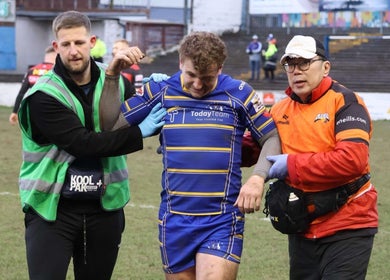 Rugby player assisted off field post-match by SM Sports Therapy, Warrington, England, GB