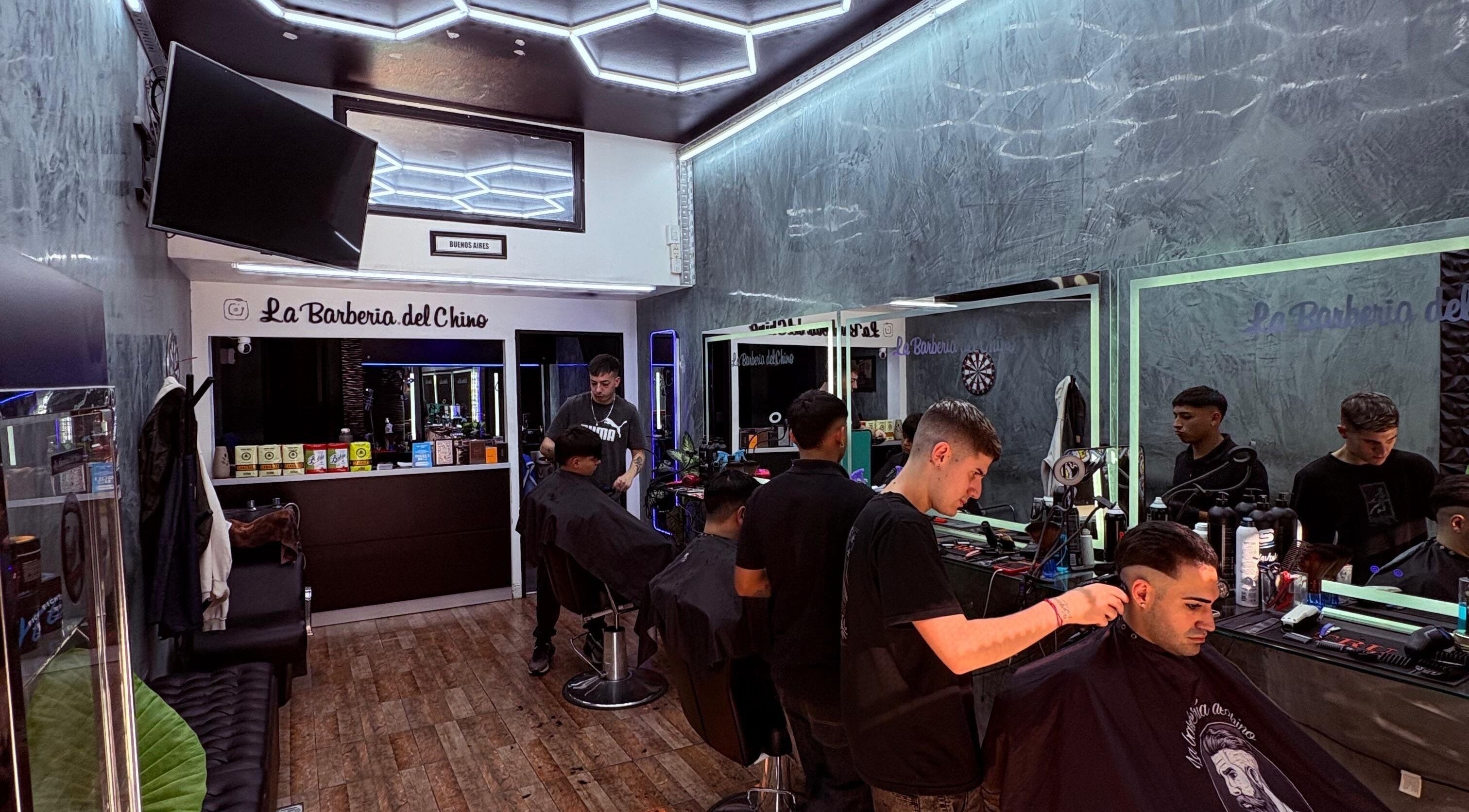 Interior de La Barbería Del Chino en Buenos Aires con barberos trabajando en clientes.