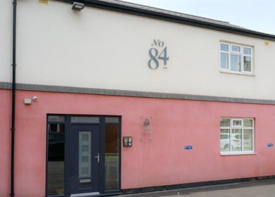 Exterior of Elite Medical, Sports Therapy and Ear Care, Shaw, England, GB with welcoming pink facade.