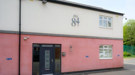 Exterior of Elite Medical, Sports Therapy and Ear Care, Shaw, England, GB with welcoming pink facade.