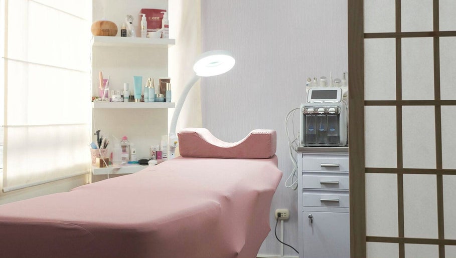 Sala de tratamiento en Tattis Roz Brows Center, Barcelona, Catalunya, ES, con camilla y luz de bienestar.