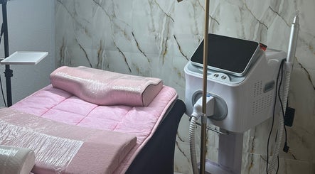 Sala de tratamiento en Tattis Roz Brows Center, Barcelona, Catalunya, ES, con cama rosa y equipo especializado.