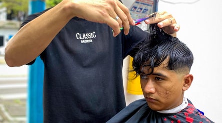 Barbero de Classic Barbería, Medellín, Antioquia, CO, realizando un corte de cabello preciso.