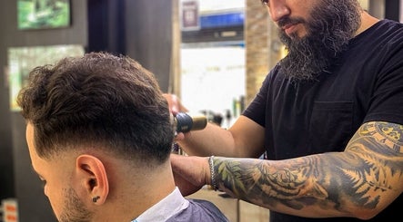 Barbero tatuado estilizando cabello en Classic Barbería, Medellín, Antioquia, CO.
