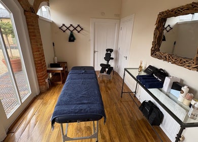 Relaxing treatment room at SRSportsRehab, Silverstone, England, GB featuring massage table and natural decor.