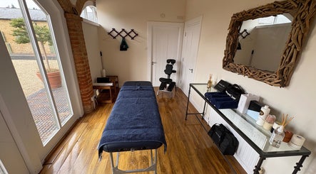 Relaxing treatment room at SRSportsRehab, Silverstone, England, GB featuring massage table and natural decor.