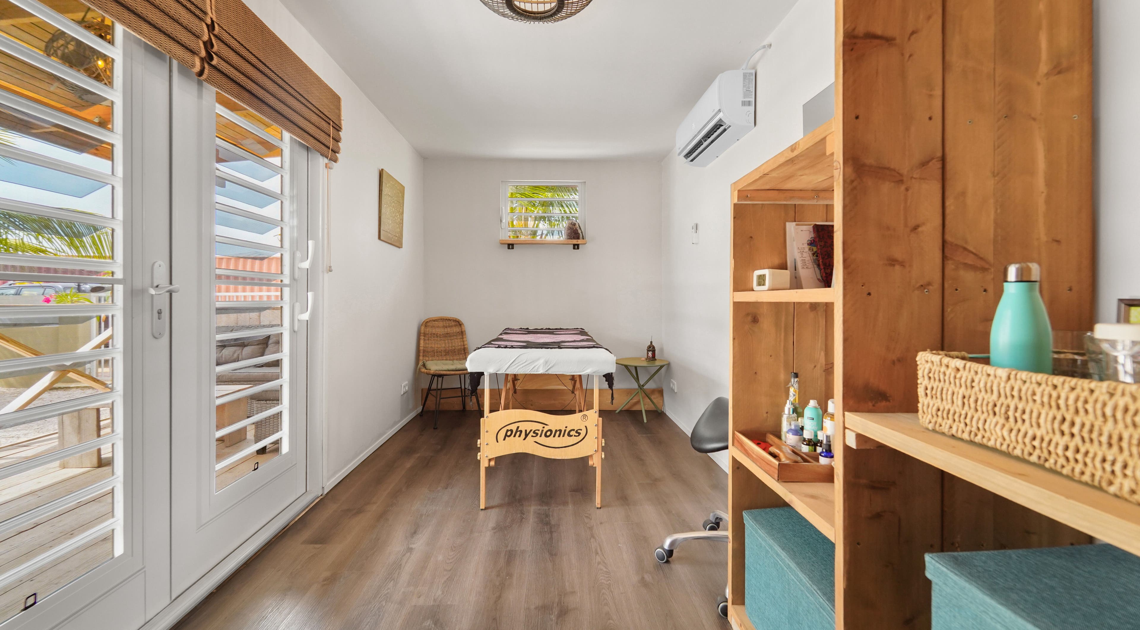 Massageruimte bij Voetreflextherapie Bonaire, Nikiboko met rustieke inrichting en houten accenten.