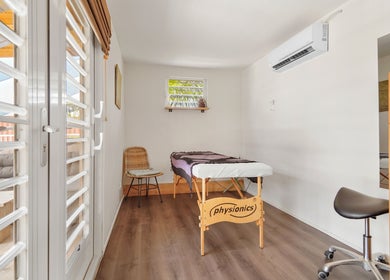 Lichte massageruimte bij Voetreflextherapie Bonaire in Nikiboko met massagetafel en houten meubels.