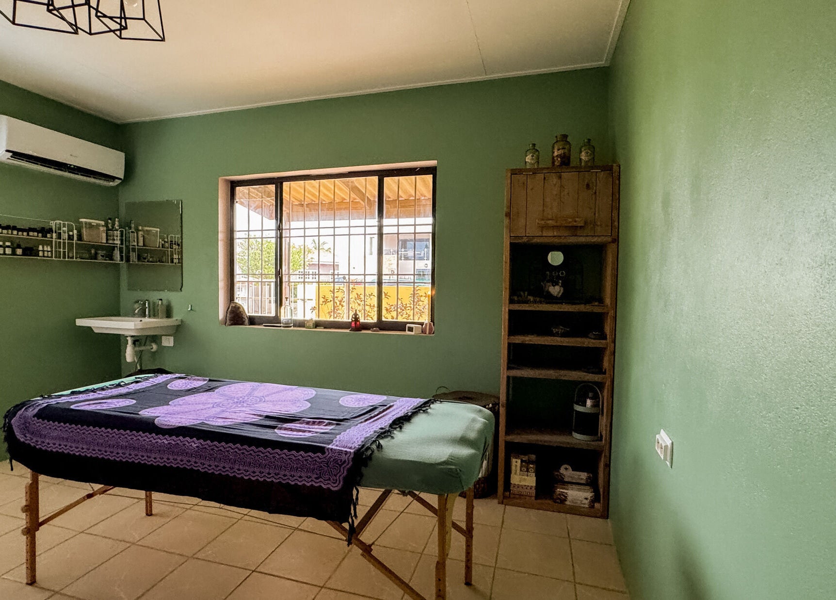 Massagekamer bij Voetreflextherapie Bonaire, Kralendijk, Bonaire met groene wanden en ontspannen sfeer.