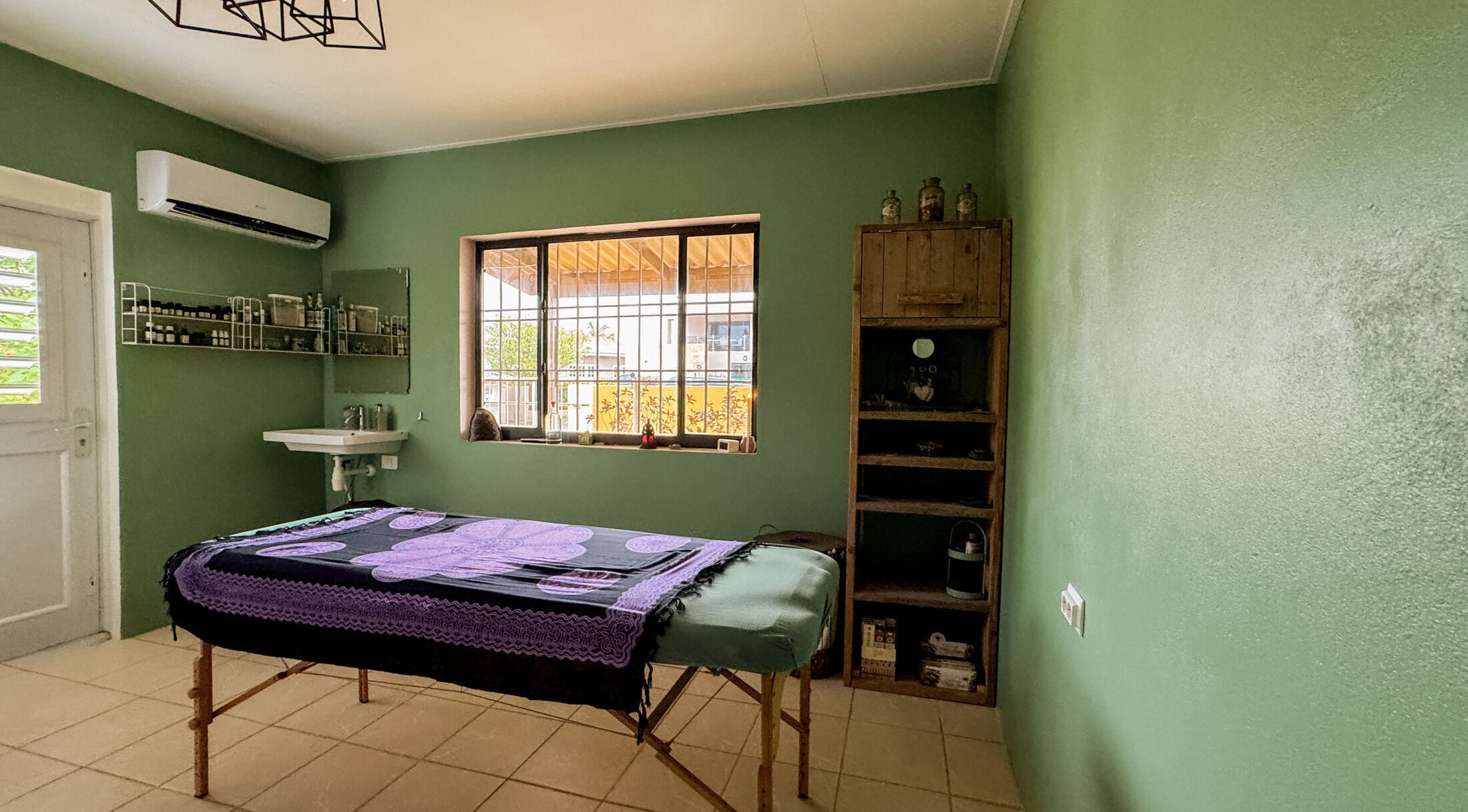 Massagekamer bij Voetreflextherapie Bonaire, Kralendijk, Bonaire met groene wanden en ontspannen sfeer.