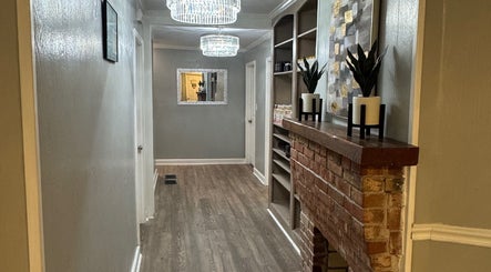 Stylish hallway at The Glow Factory, Columbia, South Carolina, US with brick feature and chic lighting.