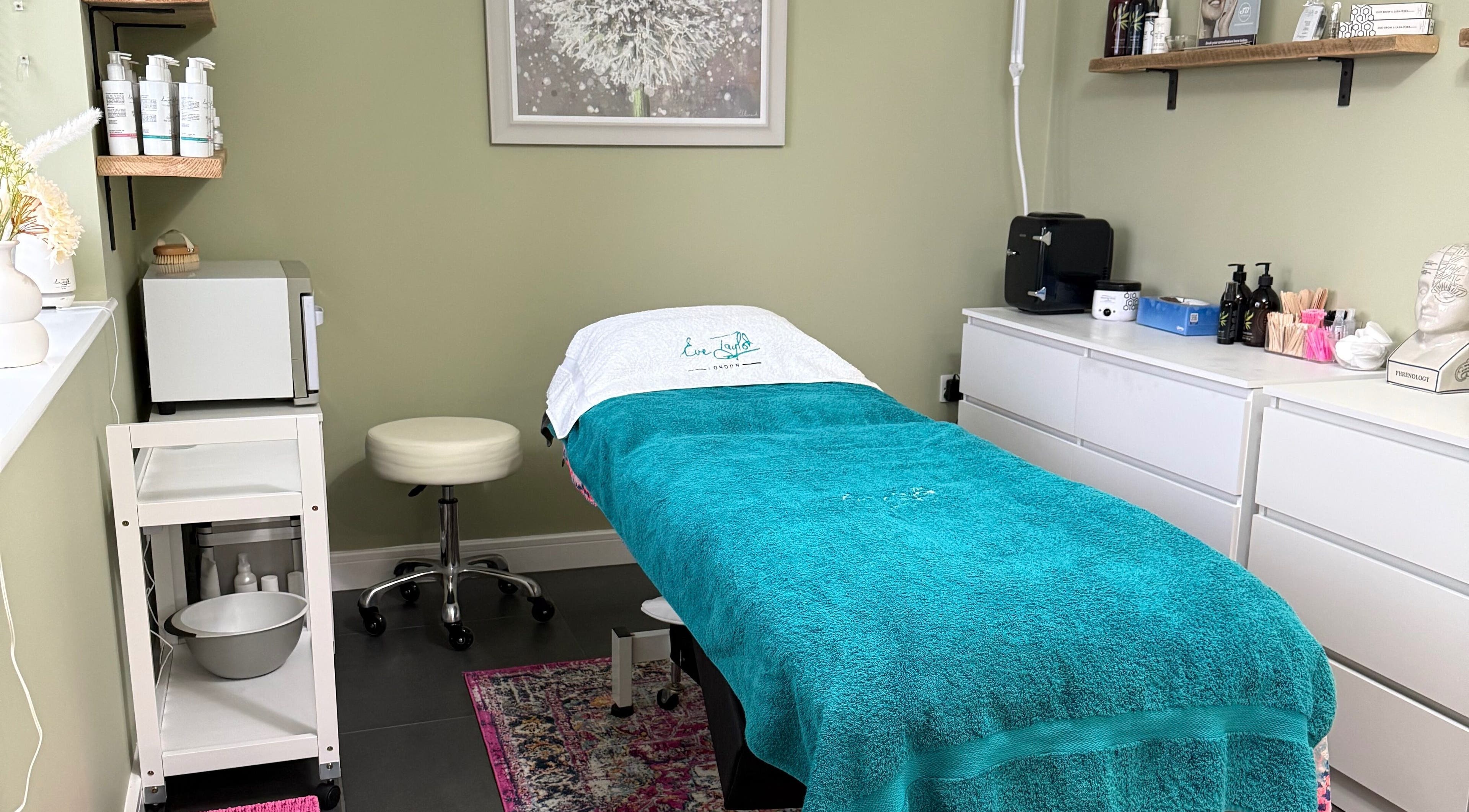 Cozy treatment room at Maggiemoo Beauty, Filby, England, GB featuring a teal-covered bed and professional spa equipment.