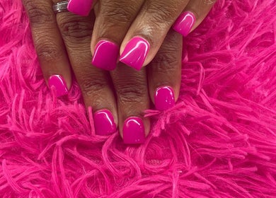 Bright pink manicured nails at Anna Nail Bar, Montego Bay, St. James Parish, JM on fluffy pink surface.