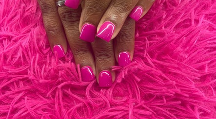 Bright pink manicured nails at Anna Nail Bar, Montego Bay, St. James Parish, JM on fluffy pink surface.
