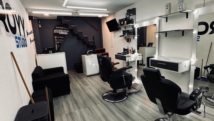 Interior moderno de Royy Studio en Concepción Del Uruguay, Entre Ríos, AR con sillas de peluquería cómodas.