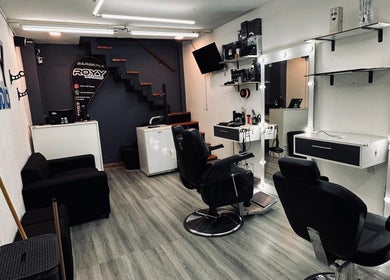 Interior moderno de Royy Studio en Concepción Del Uruguay, Entre Ríos, AR con sillas de peluquería cómodas.