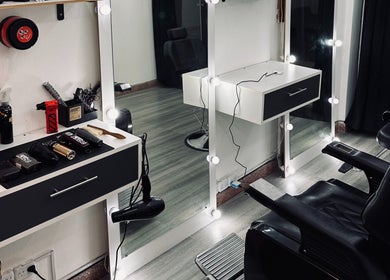 Estación de peluquería en Royy Studio, Concepción Del Uruguay, Entre Ríos, AR con espejo iluminado y silla.