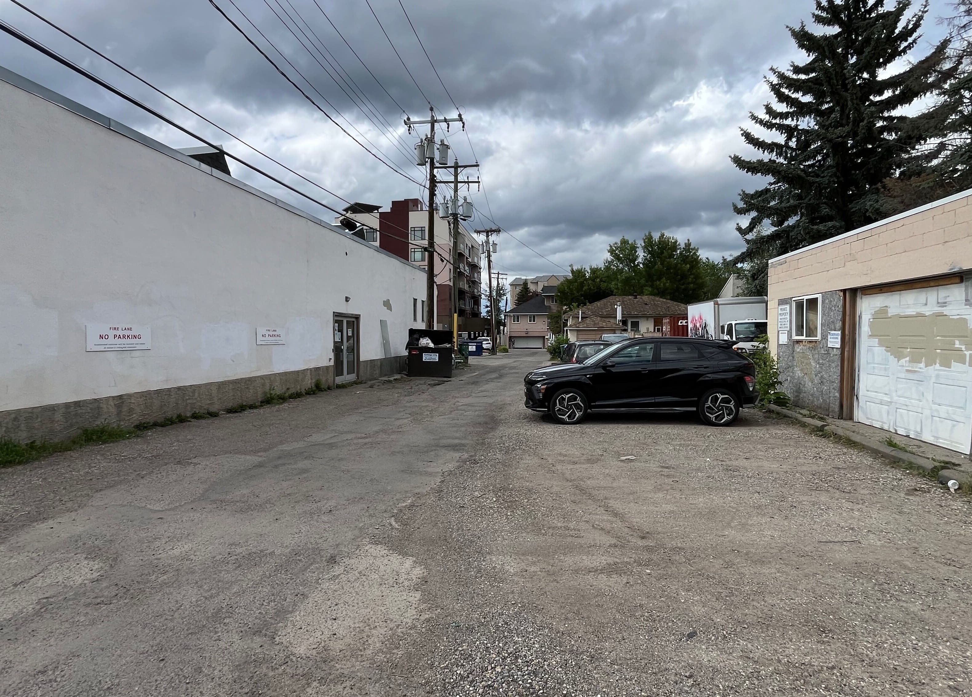 Alleyway leading to Yang’s Chinese Wellness 楊式整复按摩 in Calgary, Alberta, CA, showcasing parking access.