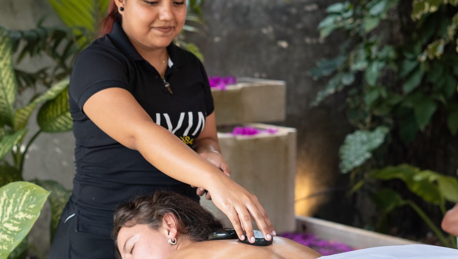 Therapist giving a hot stone massage at Livin Massage Bacalar, Bacalar, Quintana Roo, MX.