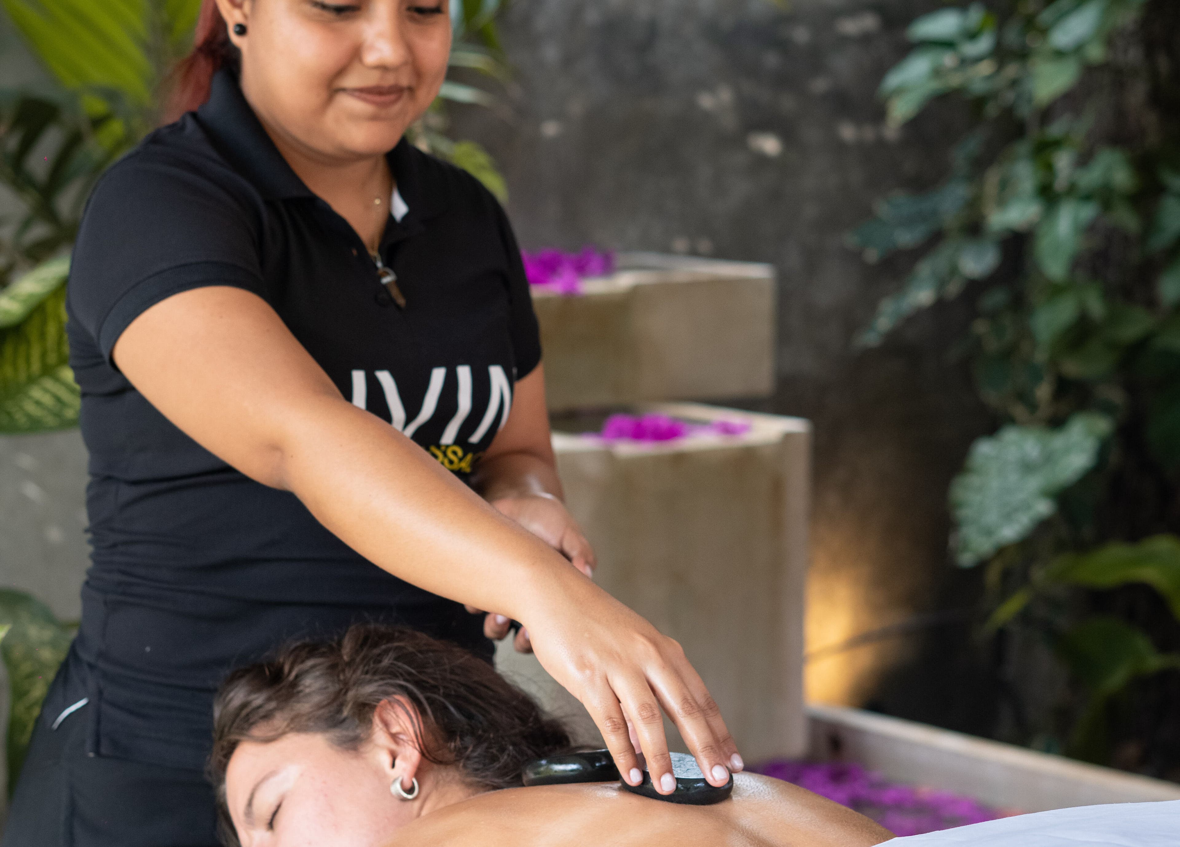 Therapist giving a hot stone massage at Livin Massage Bacalar, Bacalar, Quintana Roo, MX.