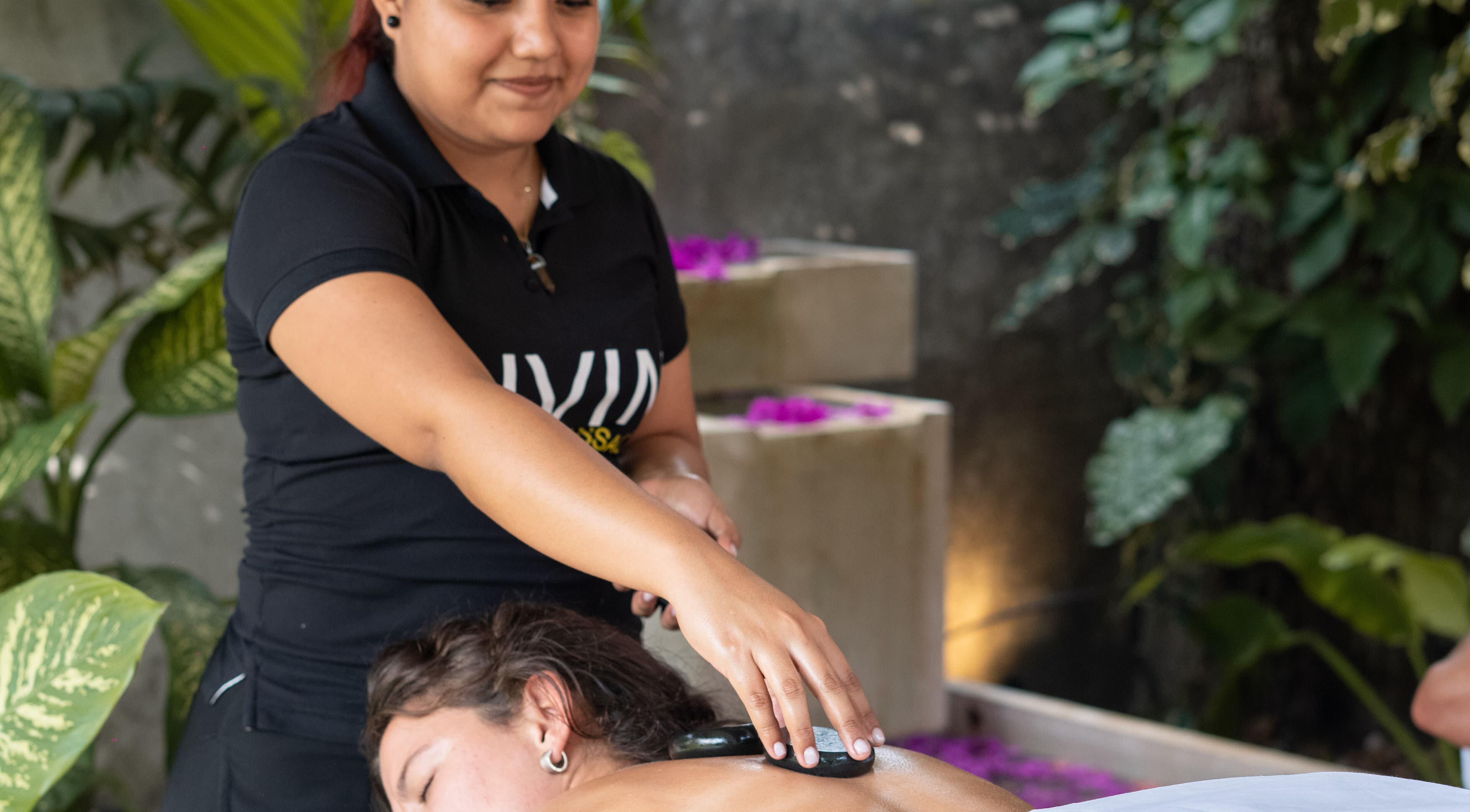 Therapist giving a hot stone massage at Livin Massage Bacalar, Bacalar, Quintana Roo, MX.