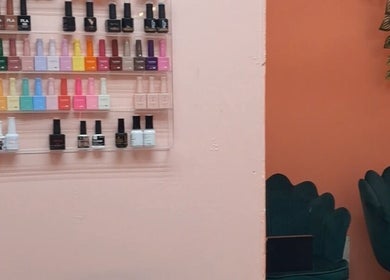 Nail polish display and seating at Zach Hair, Arima, Arima Borough Corporation, TT. Vibrant salon atmosphere.
