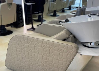 Elegant wash station at Hamza Abdulal Men Salon, Dubai, AE, featuring beige leather seating and modern design.