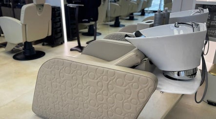 Elegant wash station at Hamza Abdulal Men Salon, Dubai, AE, featuring beige leather seating and modern design.