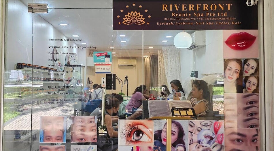 Entrance of Riverfront Beauty Spa in Singapore, showcasing services and customer engagement.