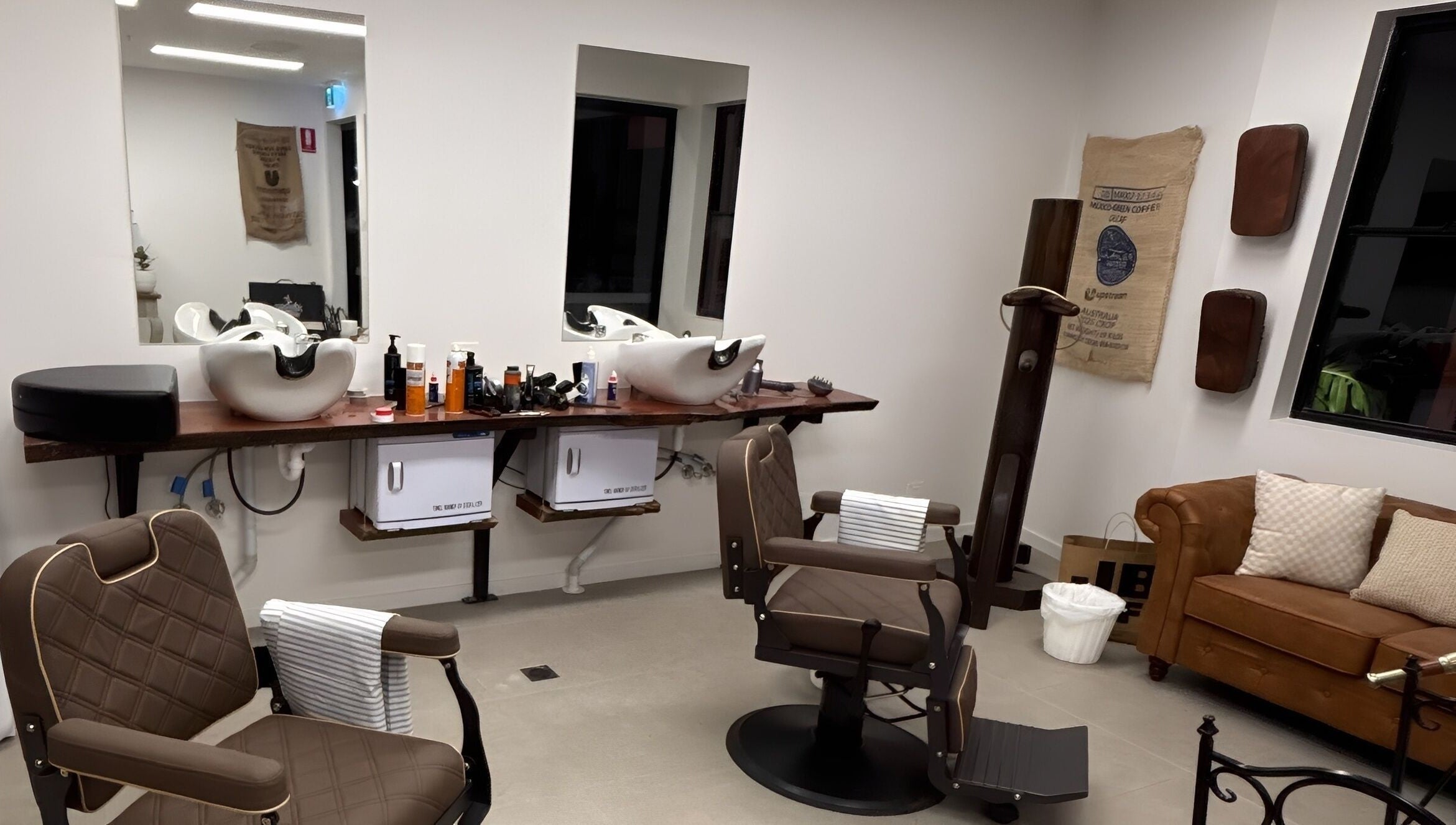 Piccante Barbers in Peregian Springs offers a stylish barber interior with chairs and a cozy couch.