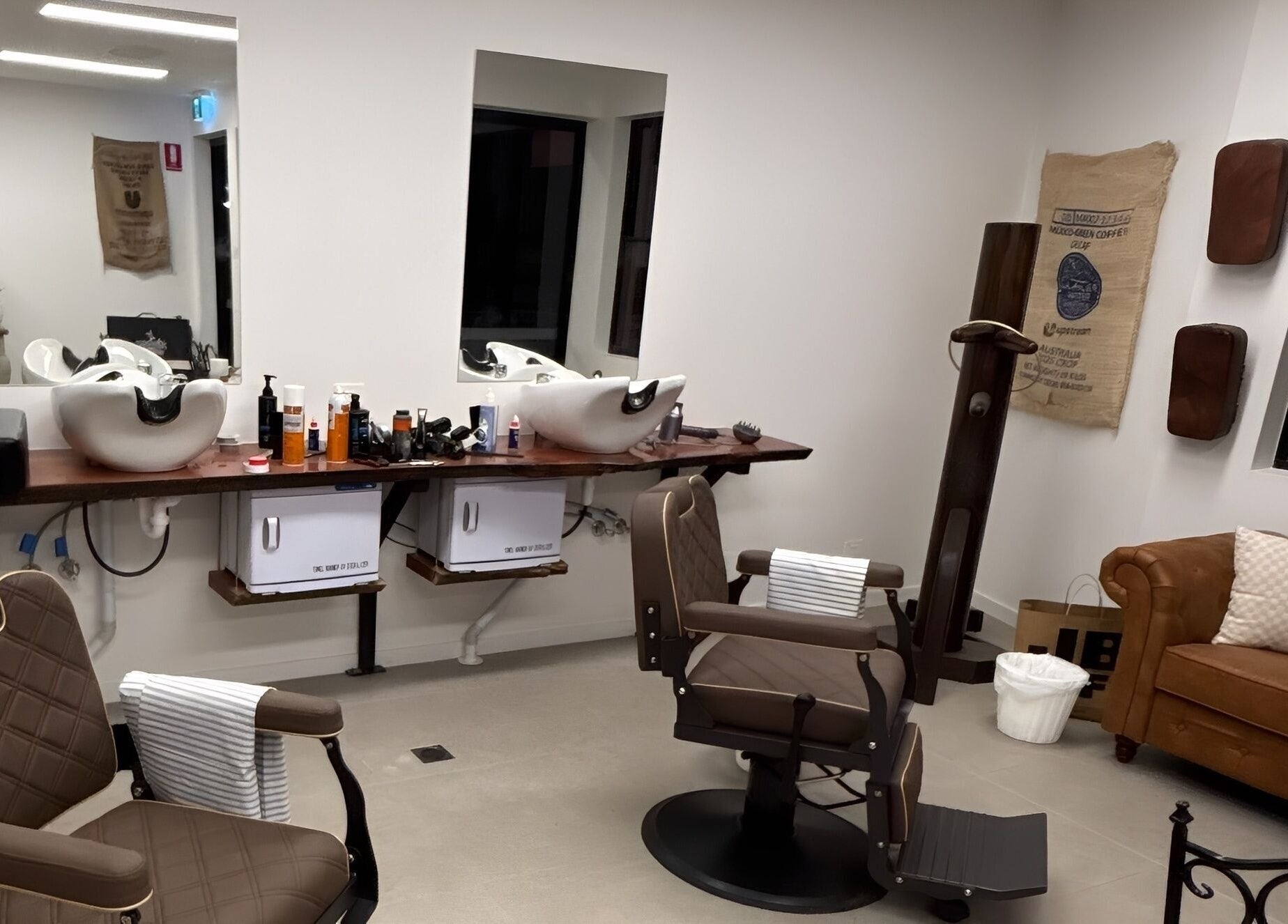 Piccante Barbers in Peregian Springs offers a stylish barber interior with chairs and a cozy couch.