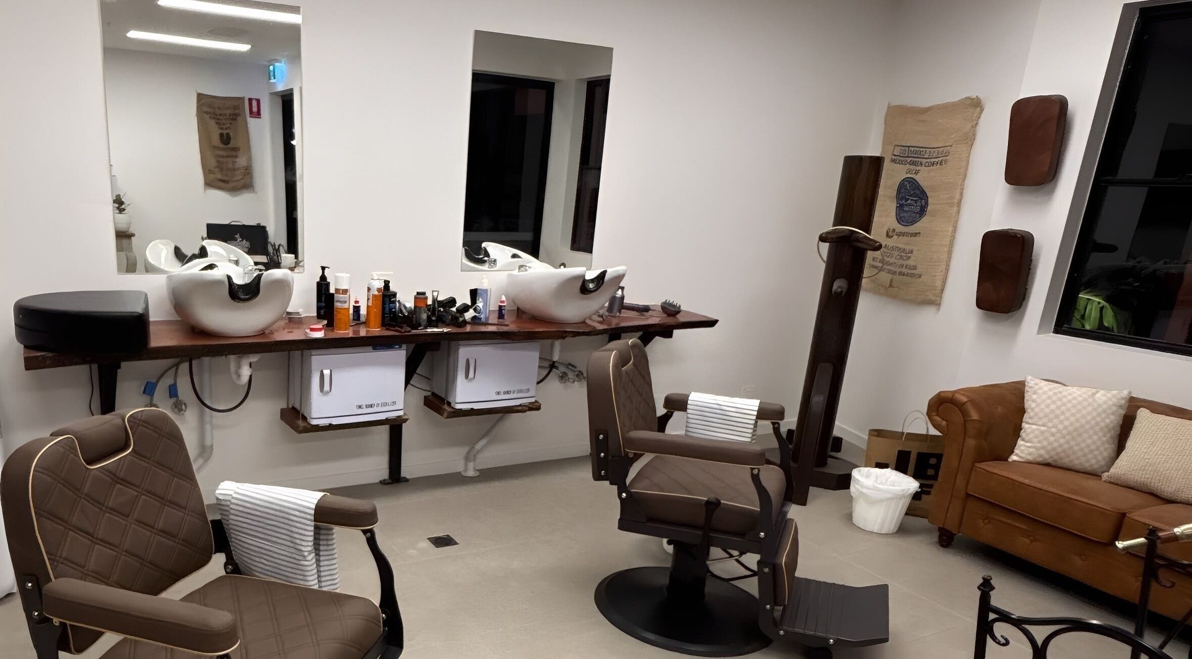 Piccante Barbers in Peregian Springs offers a stylish barber interior with chairs and a cozy couch.