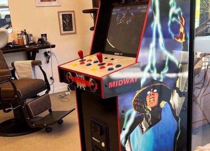 Vintage arcade game and barber chair at Piccante Barbers, Peregian Springs, Queensland, AU, creating a unique blend.