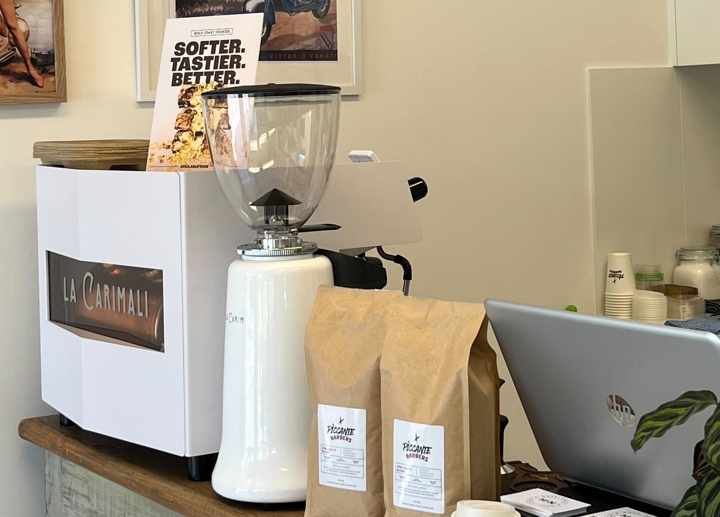Coffee setup at Piccante Barbers, Peregian Springs, Queensland, AU, featuring grinder and branded bags.