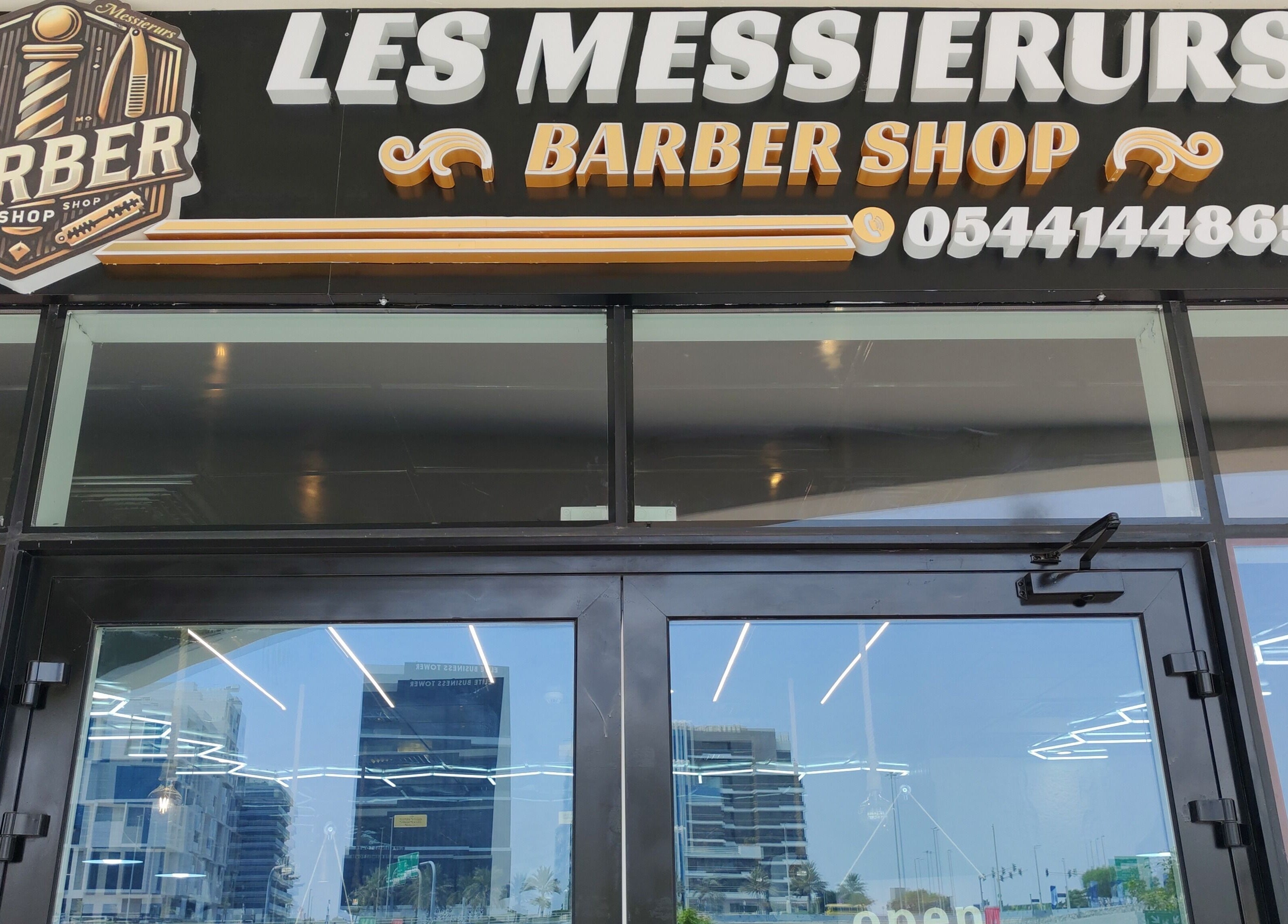 واجهة صالون Les Messieurs في أبو ظبي، أبو ظبي، AE. التصميم الأنيق يعزز جاذبية الموقع.