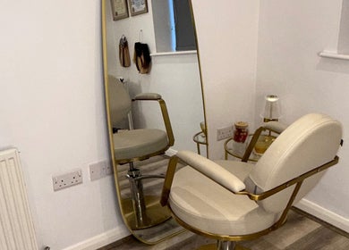 Elegant salon chair and mirror at The Dolls Lounge, Leeds, England, GB, showcasing luxury decor.