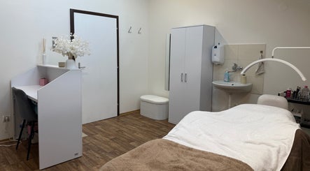 Moderní beauty místnost v SkinMax, Středočeský Kraj, CZ s masážním lehátkem a elegantní výzdobou.