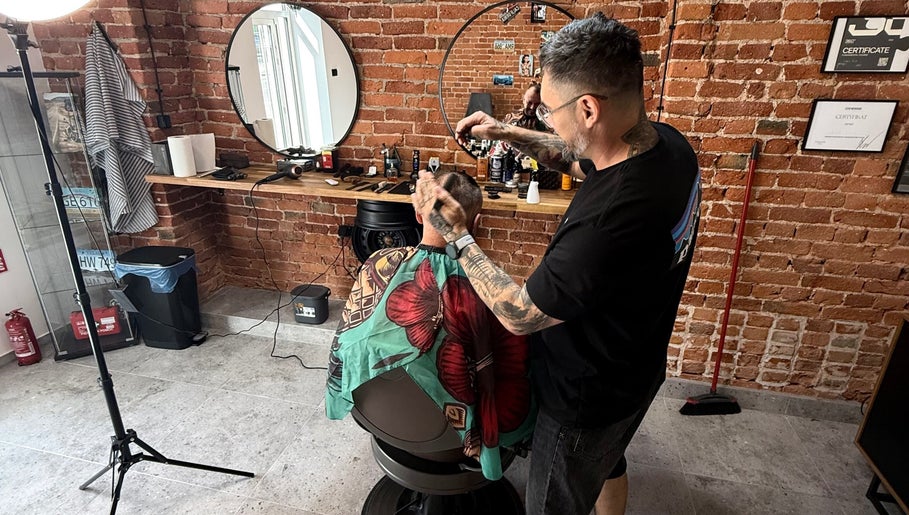 Fryzjer w Barbersota, Łódź, Województwo Łódzkie, PL, przy pracy w nowoczesnym salonie.