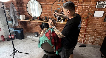 Fryzjer w Barbersota, Łódź, Województwo Łódzkie, PL, przy pracy w nowoczesnym salonie.