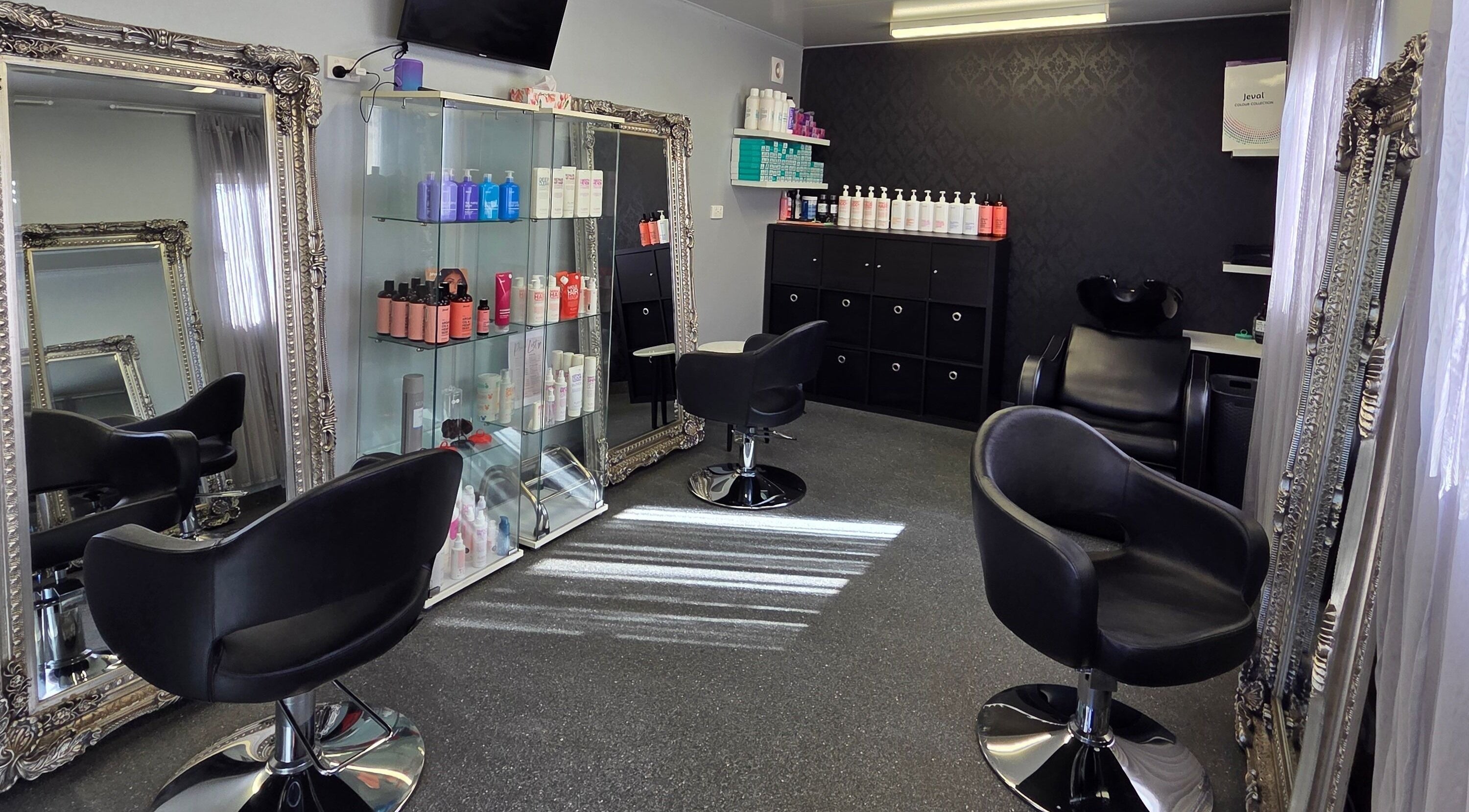 Modern salon interior at Katrina Green Hair Artistry, Tapping, WA showcasing elegant mirrors and styling chairs.