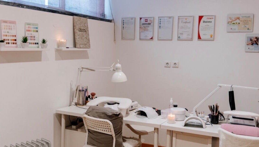 Mesa de manicure no DN Beauty Space em Mafra, Lisboa, PT, com decoração minimalista e certificados na parede.