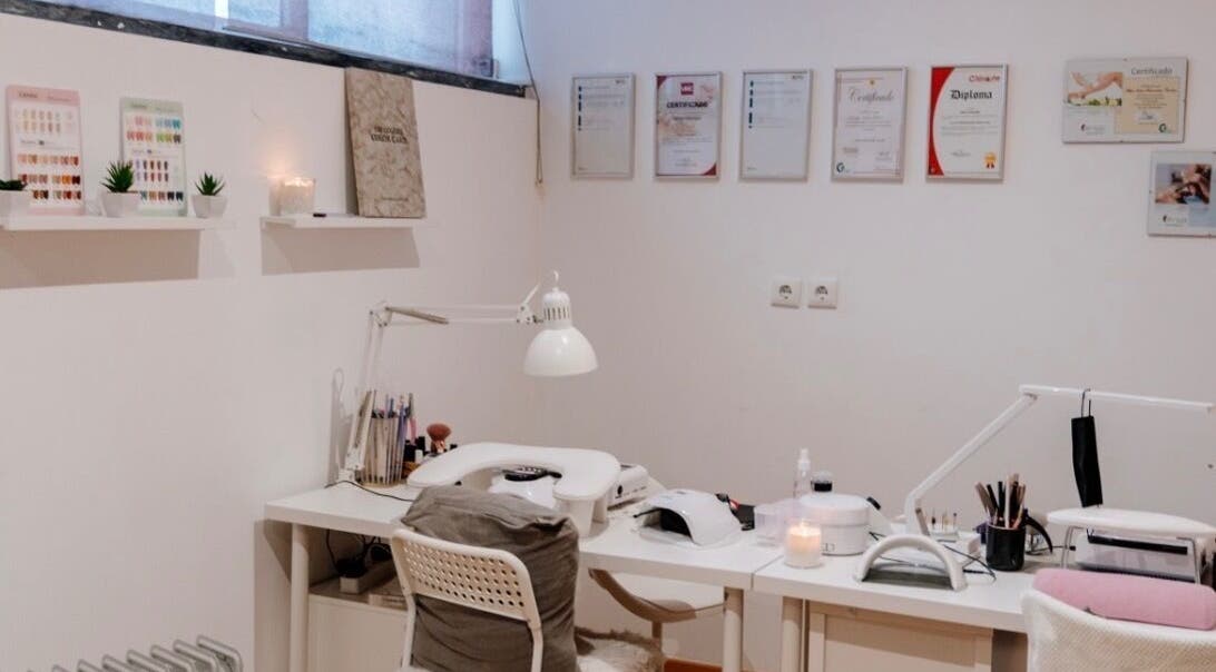 Mesa de manicure no DN Beauty Space em Mafra, Lisboa, PT, com decoração minimalista e certificados na parede.
