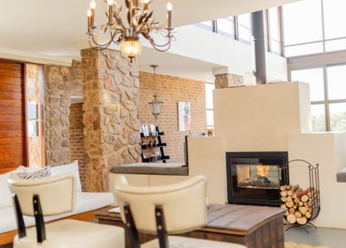Charming lounge with rustic stone and fireplace at Vygenhoek Spa & Farmhouse in Dullstroom, Mpumalanga, ZA.