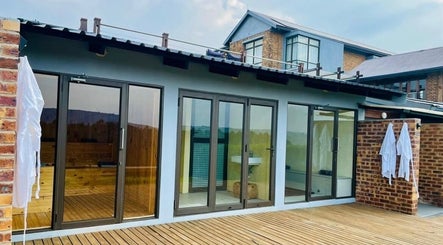 Vygenhoek Spa & Farmhouse's serene deck in Dullstroom, Mpumalanga, ZA, with robes and glass doors.