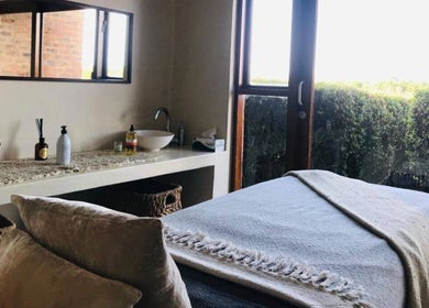 Relaxing spa room at Vygenhoek Spa & Farmhouse in Dullstroom, Mpumalanga, ZA with massage table and window view.
