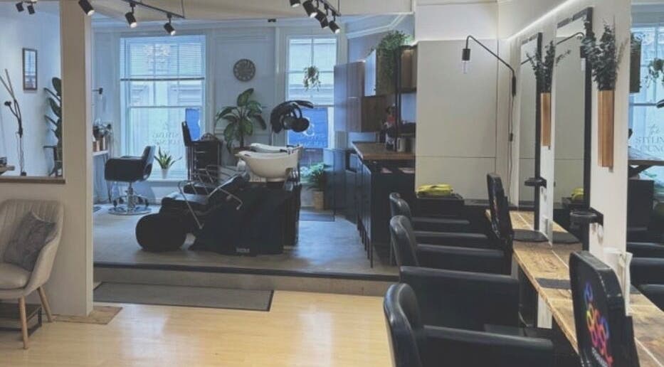 Modern salon at Hair By JT, featuring sleek chairs and mirrors in Norwich, England, GB.