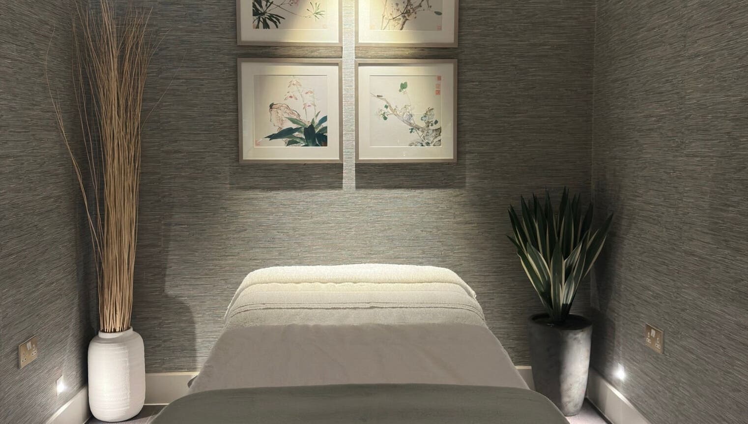 Tranquil massage room at Reflex Harmony, Cirencester, England, GB, featuring soft lighting and elegant decor.