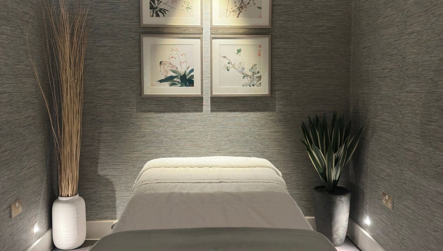 Tranquil massage room at Reflex Harmony, Cirencester, England, GB, featuring soft lighting and elegant decor.
