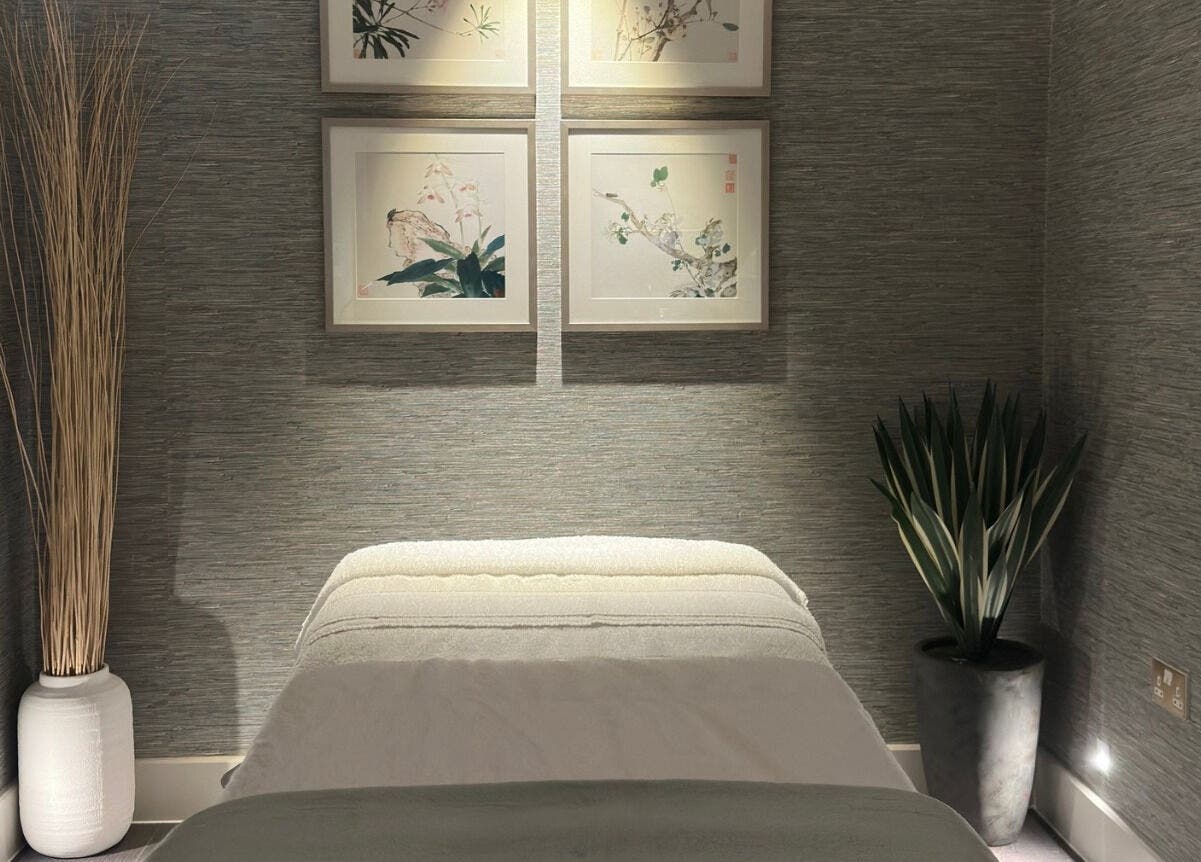Tranquil massage room at Reflex Harmony, Cirencester, England, GB, featuring soft lighting and elegant decor.